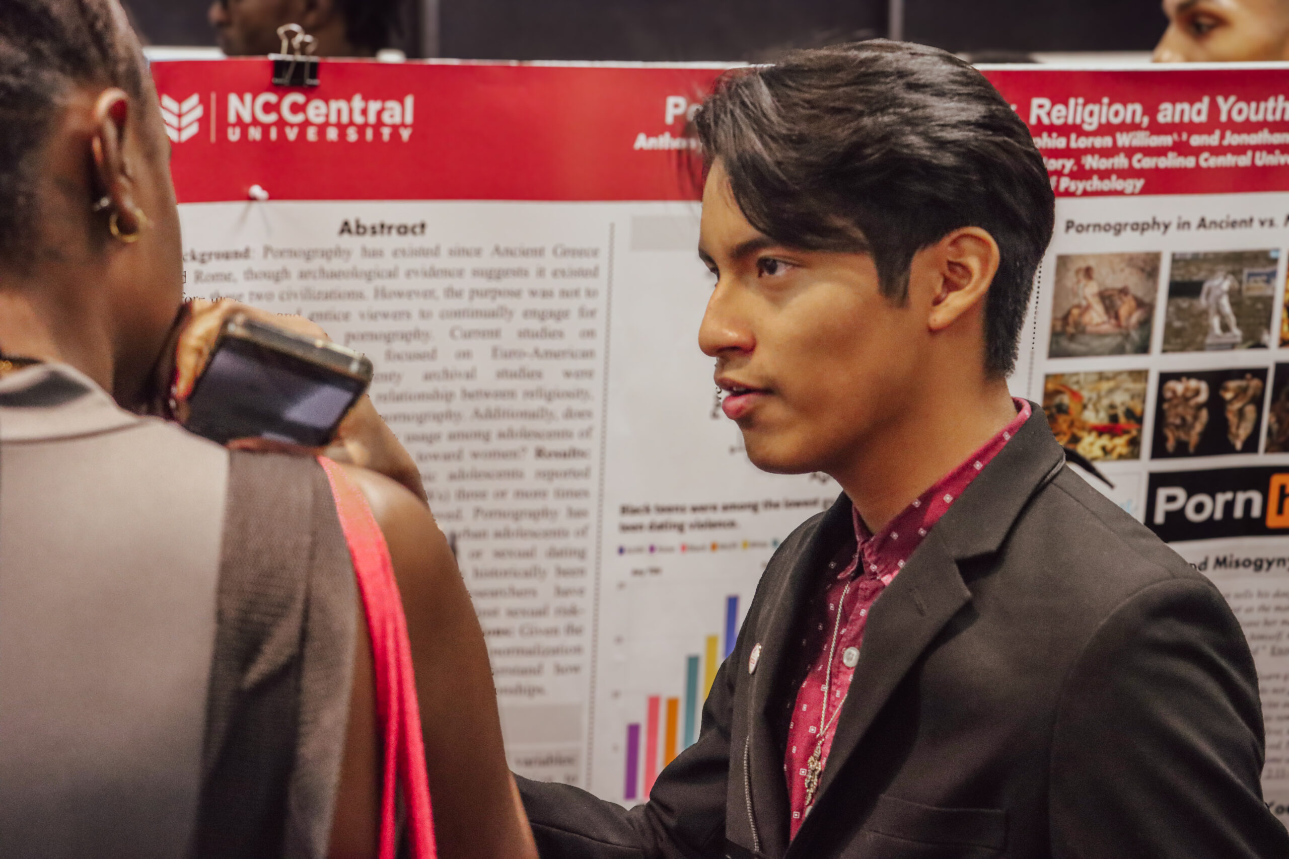 Anthony sharing his research to a fellow student.